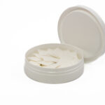 Nicotine pouches in an open white container displayed on a white background as a product photo